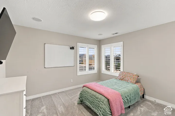 Recessed ceiling speakers, flush-mount ceiling light, plantation shutters, and light-tone wall paint
