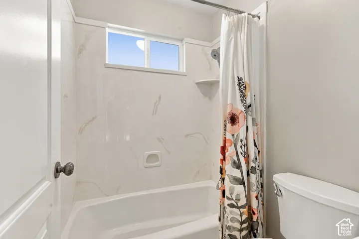 Bathtub with tile surround, built-in soap dish, and a window