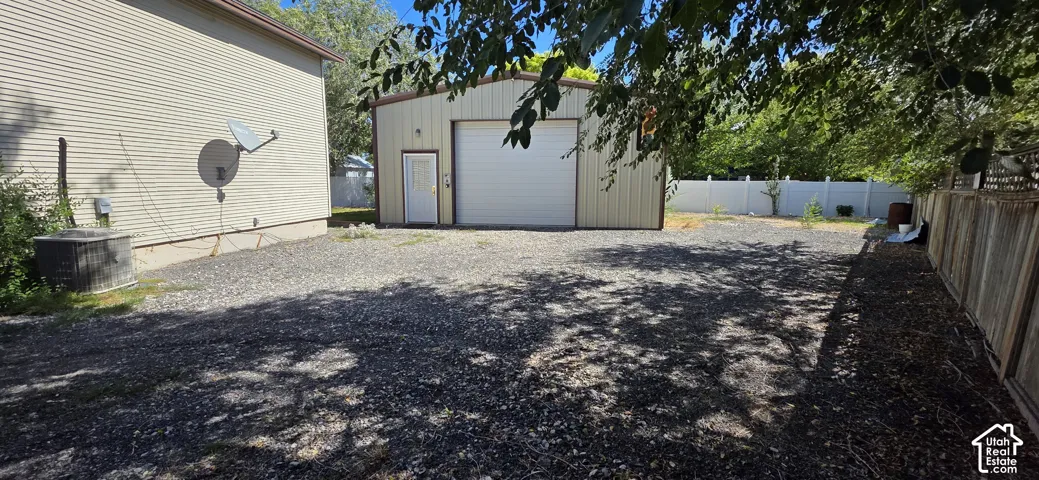 Metal-sided detached garage with overhead door and side entry