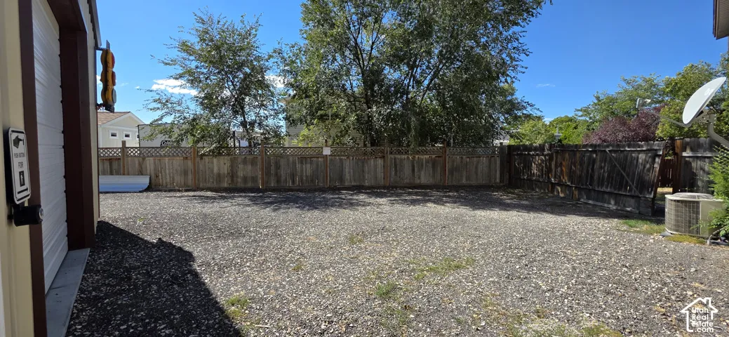 Gravel yard with a full-height wooden fence