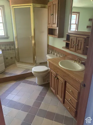 Vanity with wood-finish cabinetry, integrated sink, and an expansive mirror