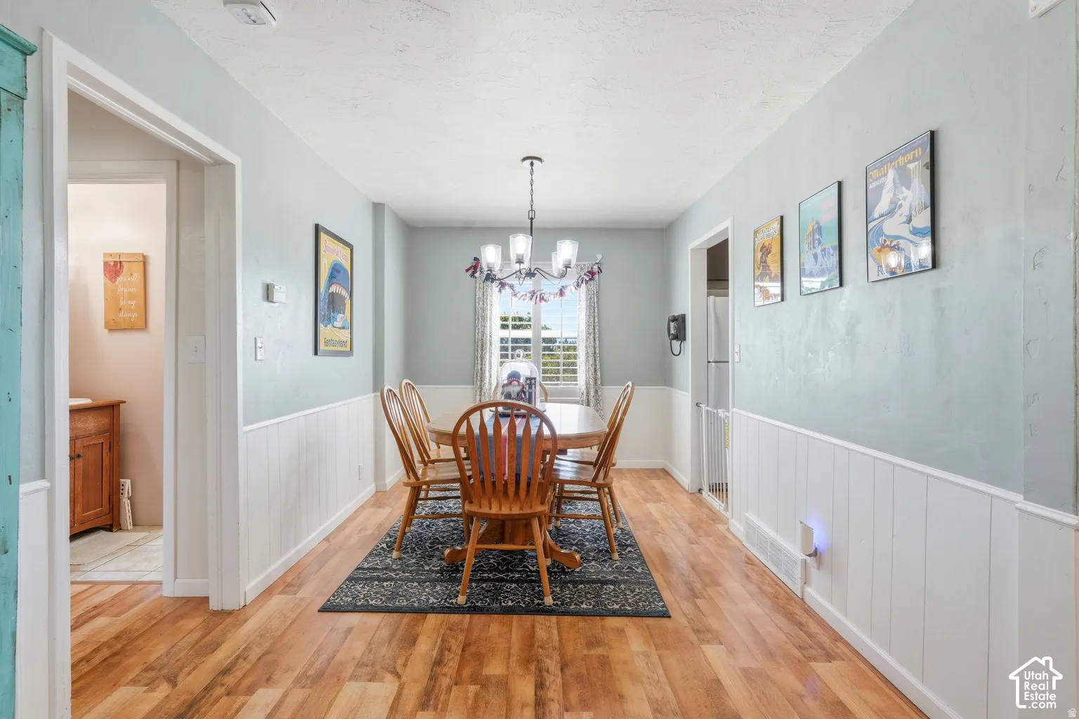 Wood-finish flooring, wainscoting, and a window with natural light