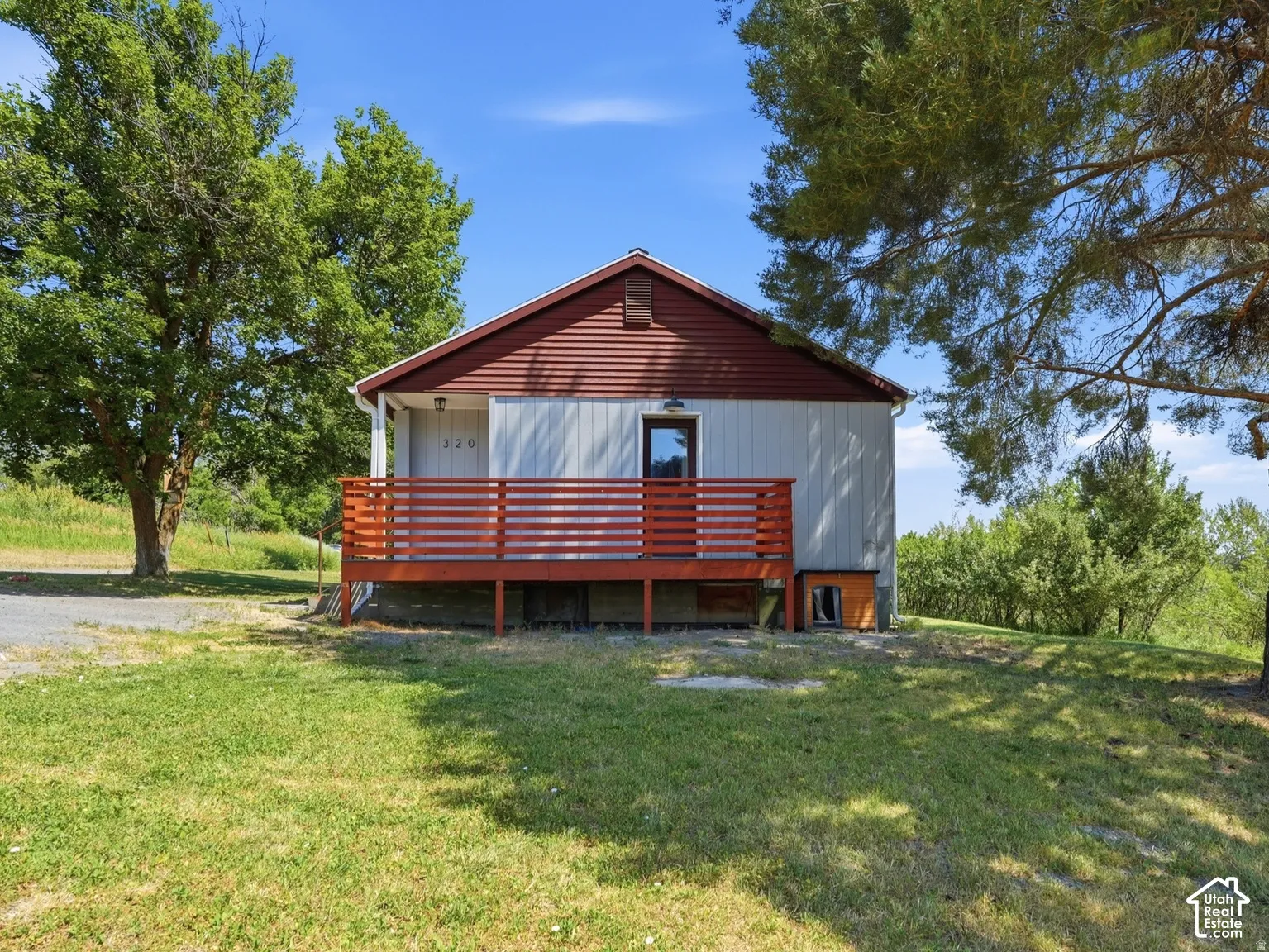 Exterior with horizontal siding, a red gabled roof, and a wood deck featuring horizontal railings