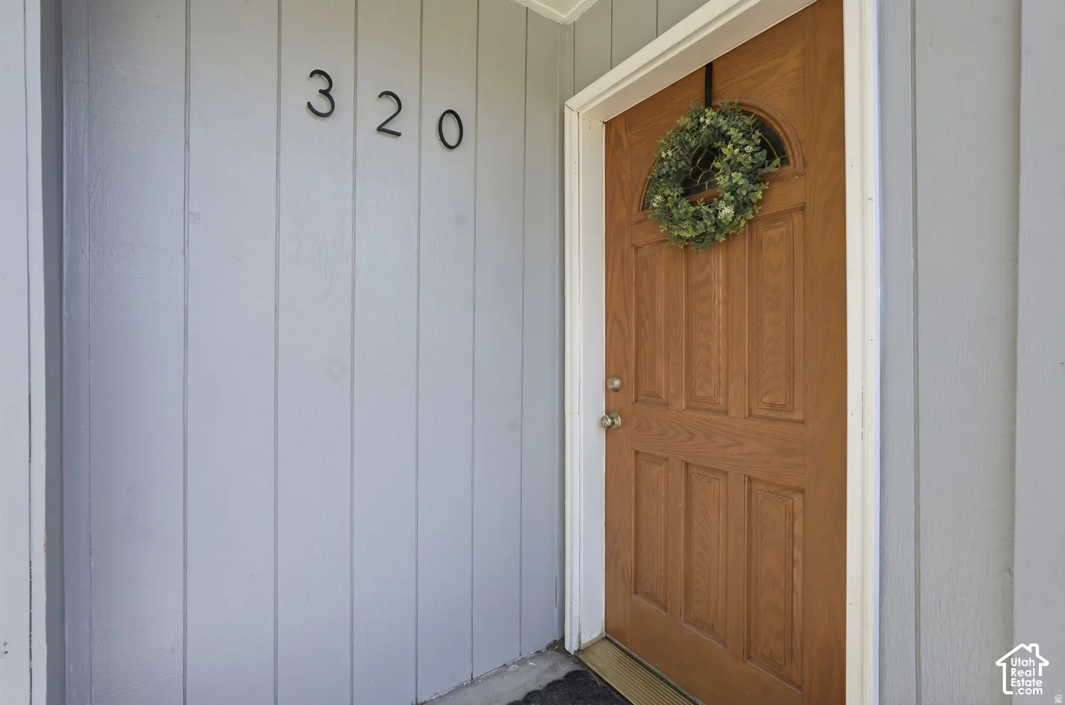 Wood-paneled entry door with an arched transom window