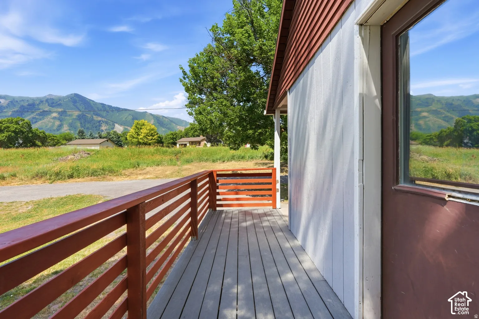 Outdoor decking with horizontal wood railing, offering expansive mountain scenery