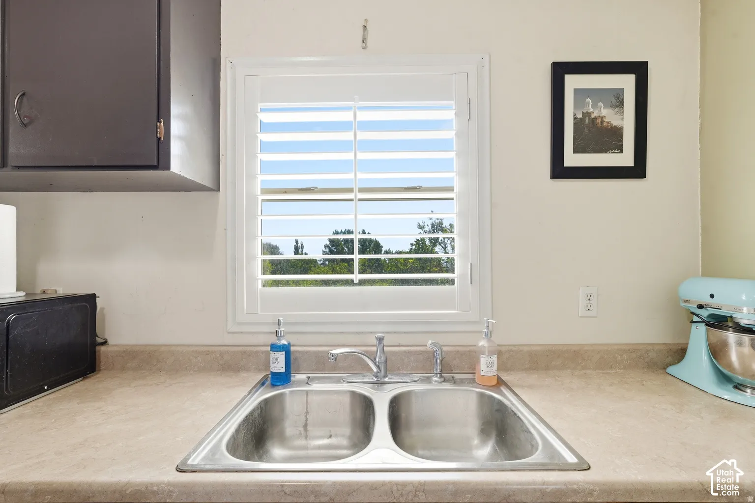Double basin stainless steel sink with a single-handle faucet, set into a laminate countertop