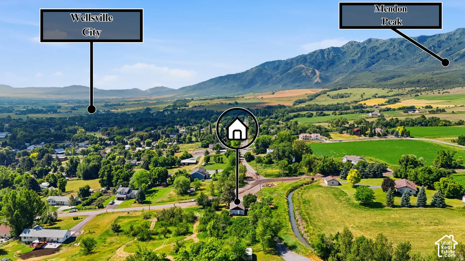 Expansive rural landscape featuring distant mountains and surrounding properties