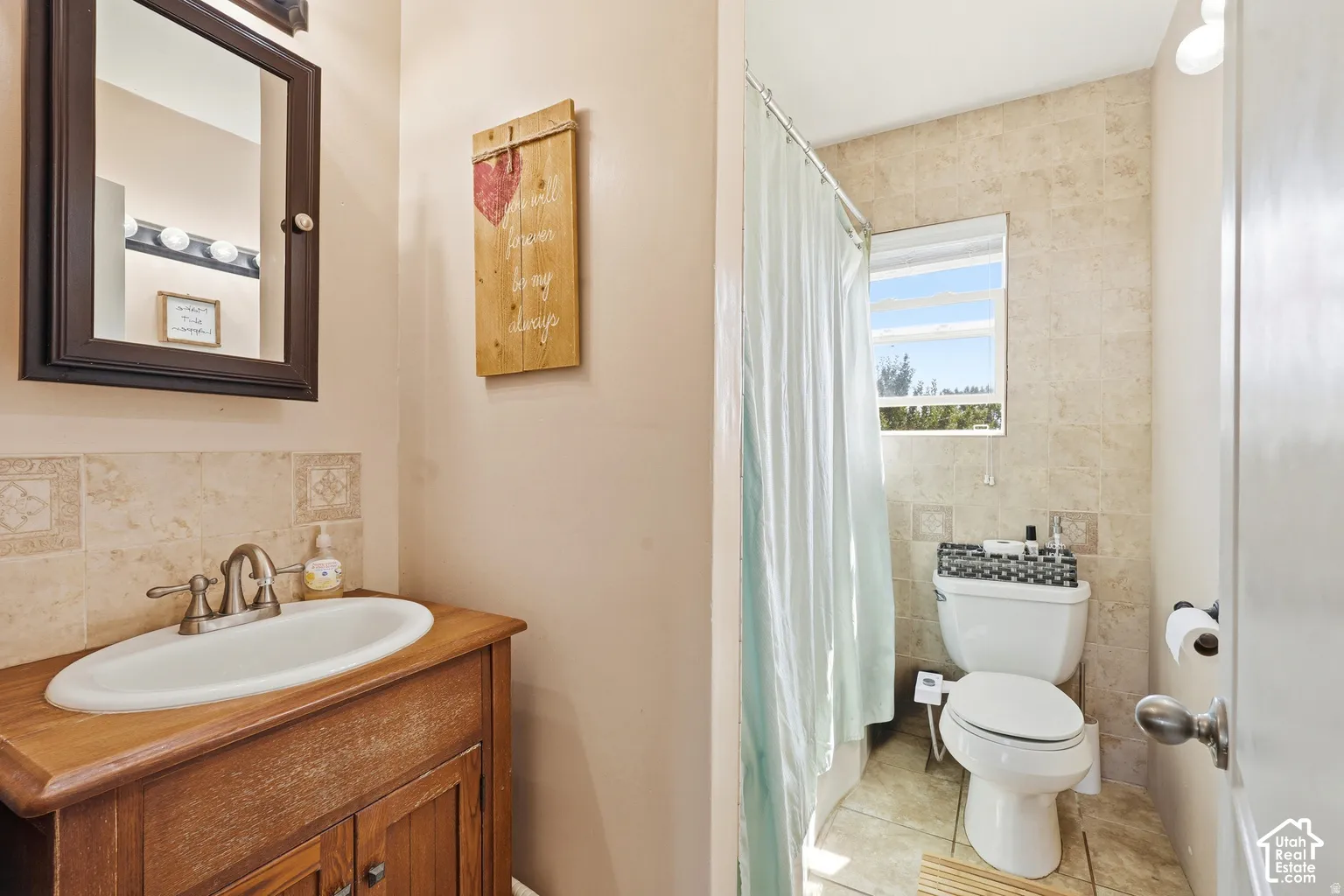 Wood-finish vanity with an integrated sink and tiled backsplash