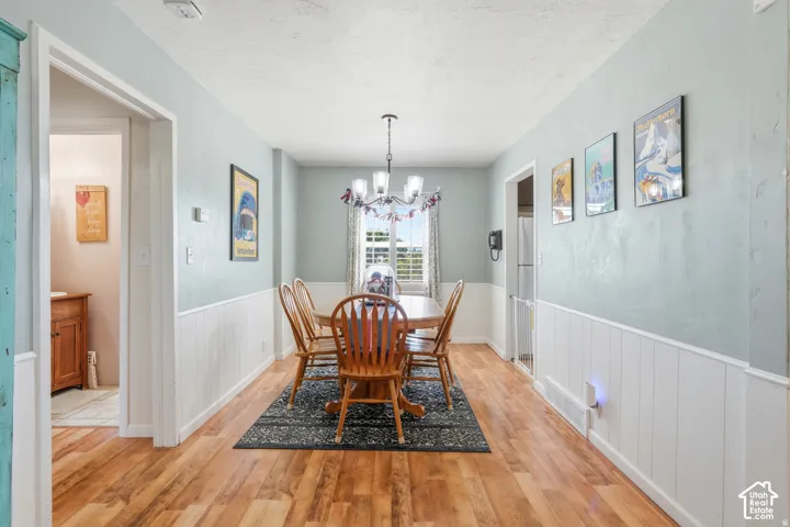 Wood-finish flooring, wainscoting, and a window with natural light