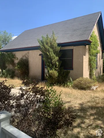 Detached garage with stucco exterior and pitched shingle roof