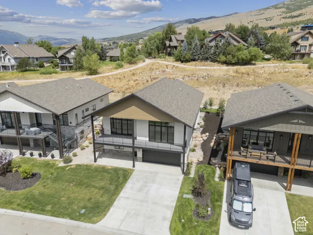 Modern architectural design featuring prominent balcony, integrated garage, and a concrete driveway