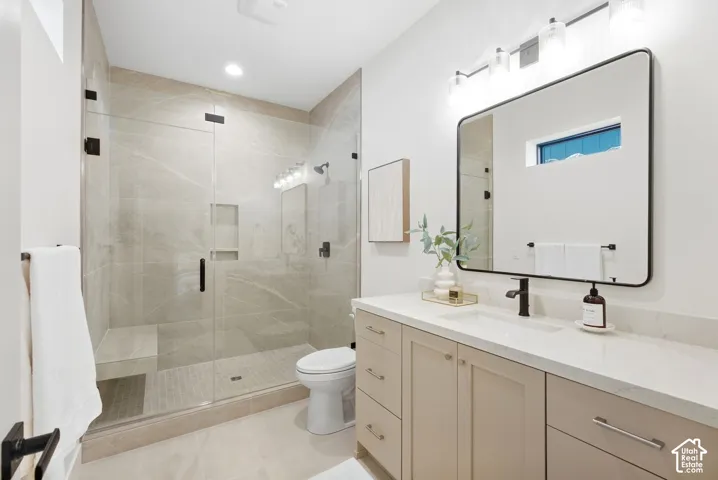 Walk-in shower with a glass enclosure, built-in bench, and tiled walls