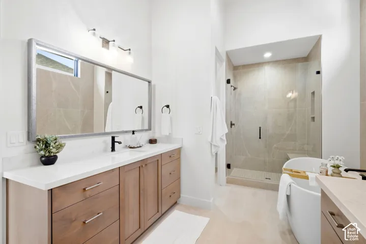 Large vanity with wood-finish cabinetry, white countertop, and rectangular mirror