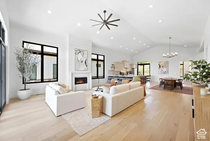 Vaulted ceilings, recessed lighting, wood-finish flooring, black-framed windows, and a built-in fireplace with shiplap accent wall