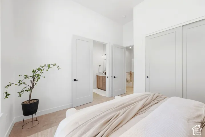 White walls, carpet flooring, flat panel interior doors, and sliding closet doors with black hardware