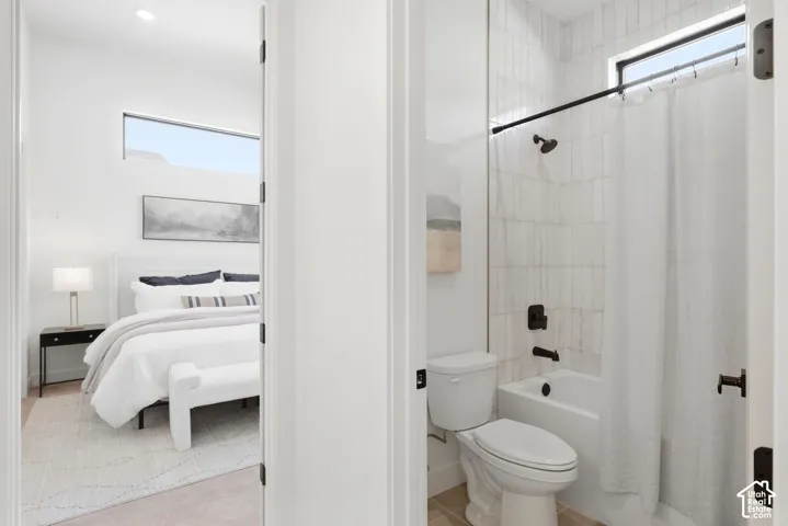 White tile shower surround with dark bronze fixtures and an integrated bathtub