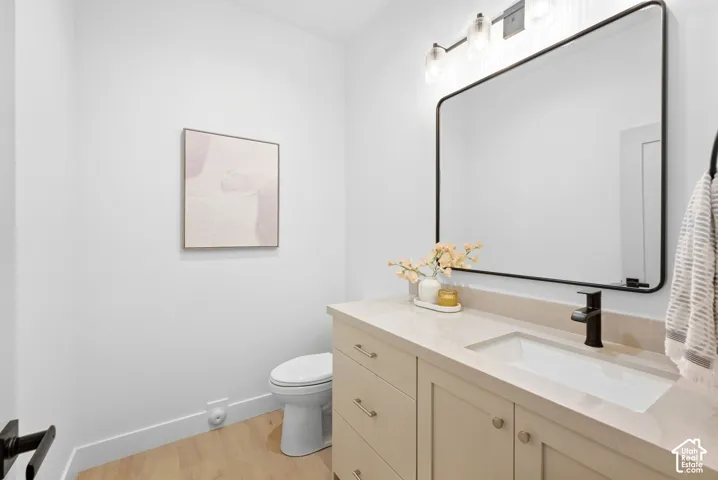Powder room featuring a single vanity with a light-toned countertop, undermount sink, and matte black faucet