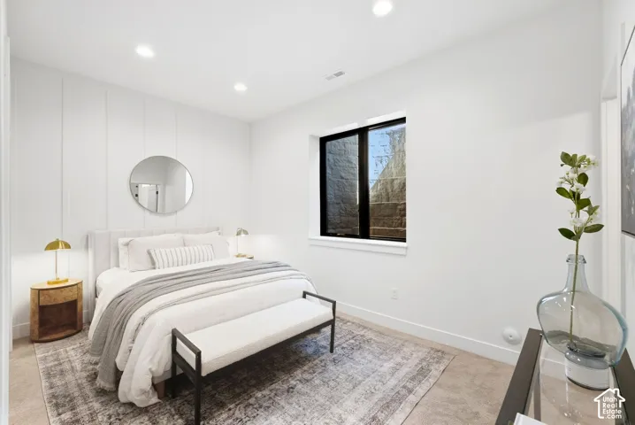 Vertical wall paneling, recessed lighting, sleek black window frame, and neutral wall tones