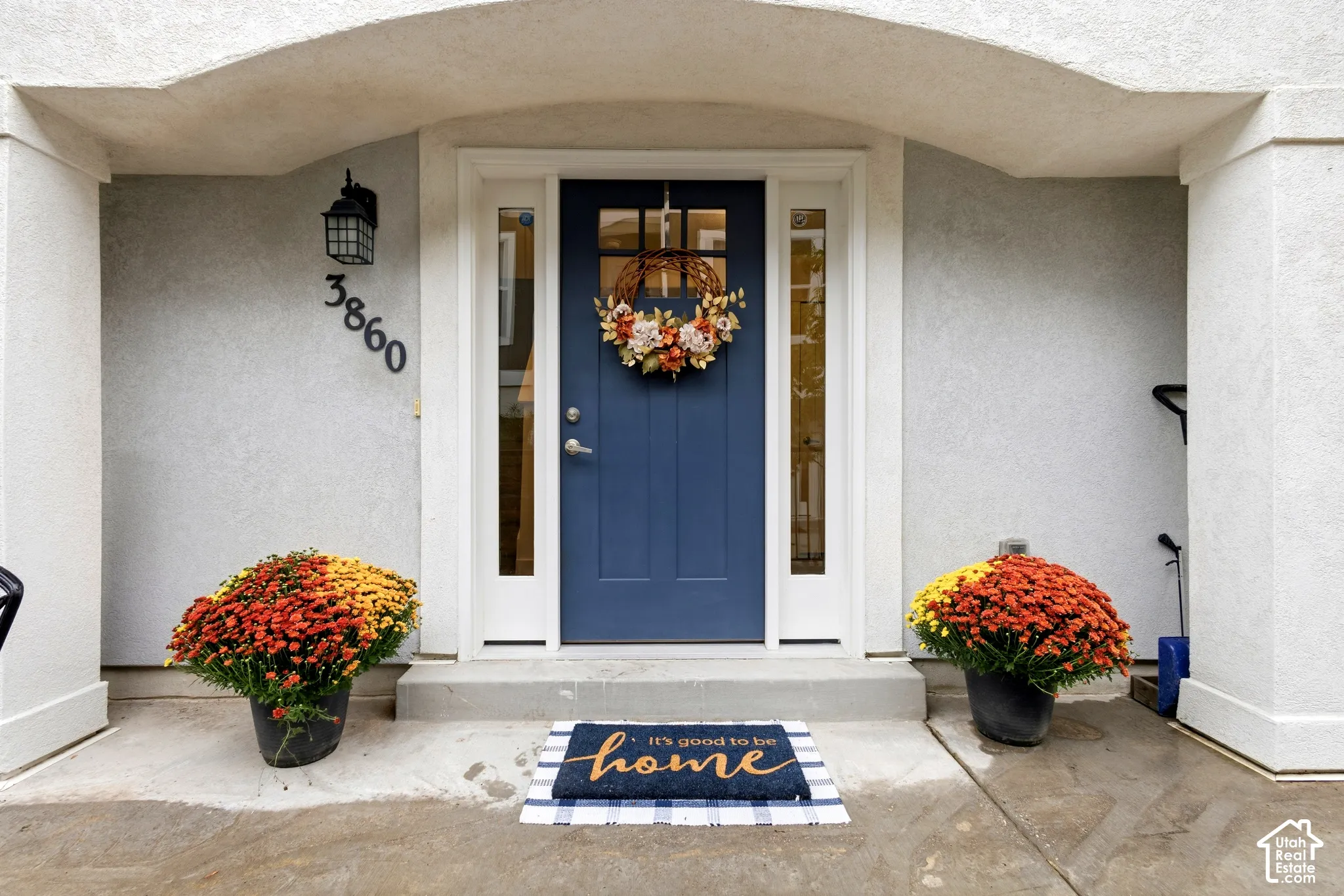 Arched portico entrance with stucco exterior and detailed address numbers