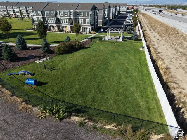 Expansive turf area with perimeter fencing, a white vinyl privacy fence, and a designated activity zone