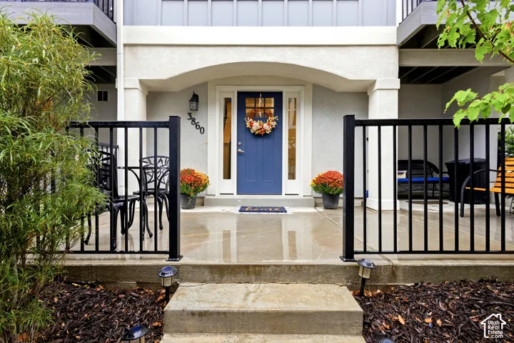 Stucco exterior with an arched entry, a blue front door with a sidelight, and black metal railings