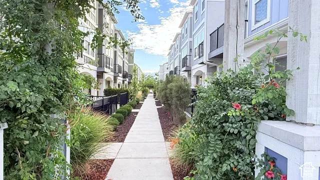 Path with manicured landscaping, multi-story residences with balconies
