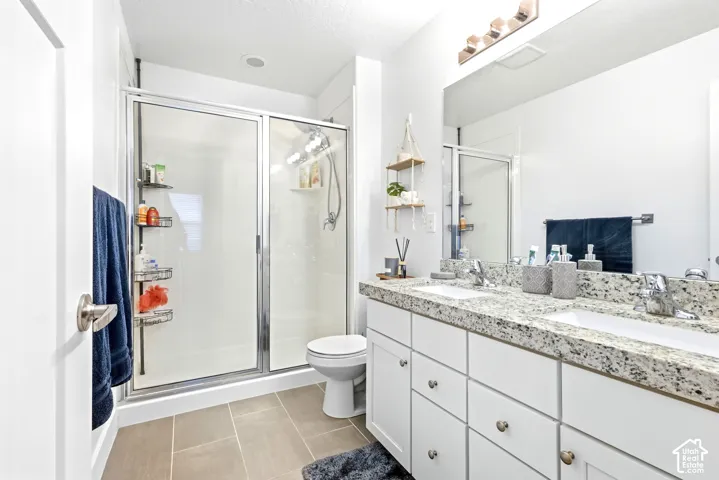 Dual vanity with granite-style countertop, white cabinetry, and brushed nickel hardware