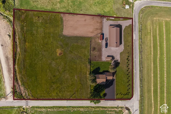 Expansive property featuring a main residence, a secondary outbuilding, and a large open field