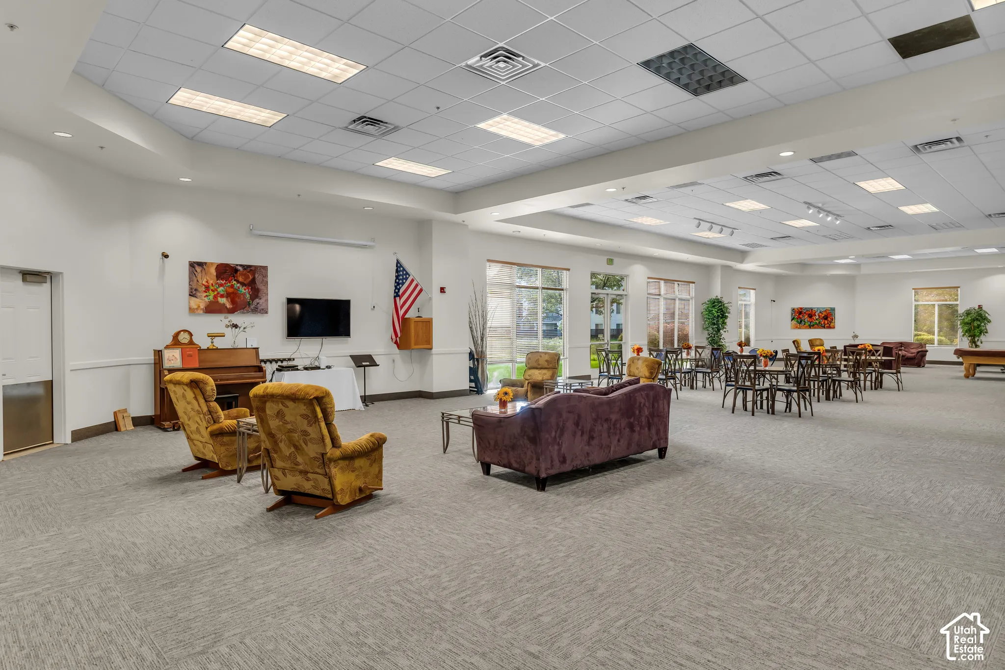 Spacious common area featuring patterned carpeting and recessed lighting