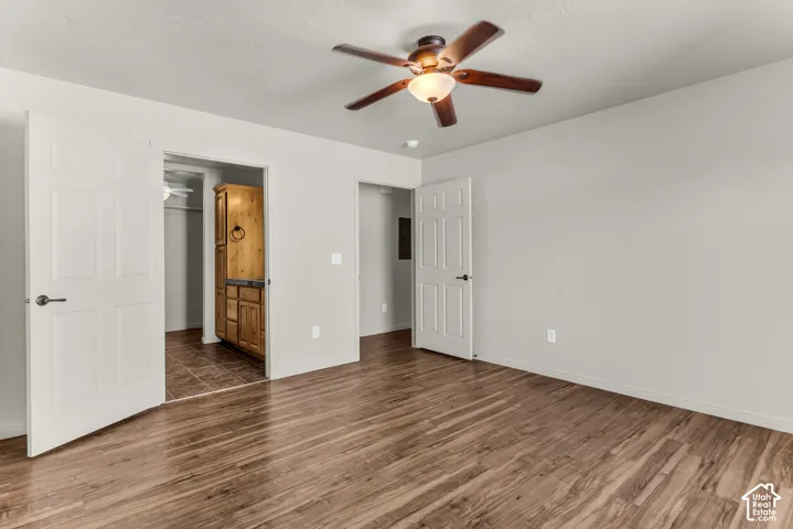 Wood-finish flooring, ceiling fan with integrated lighting, and neutral wall tones