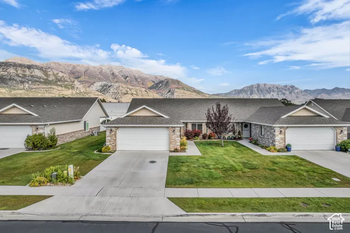 Single-story residence featuring a stone and siding exterior, an attached garage, and a concrete driveway
