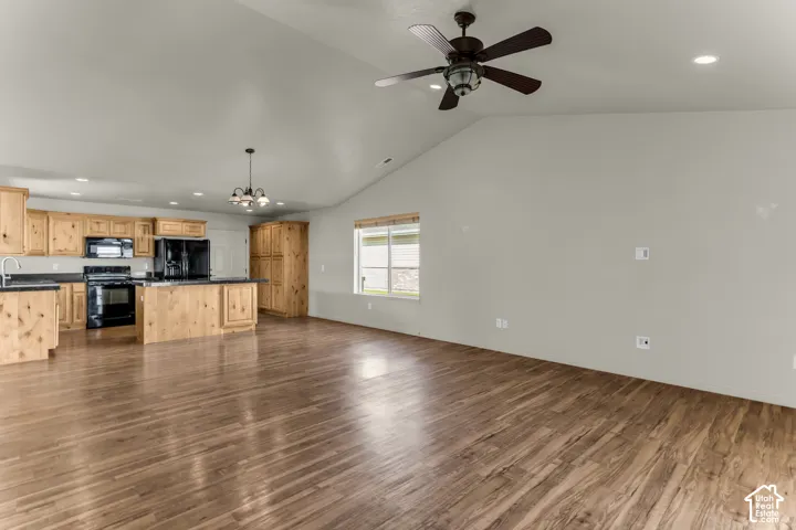 Open-concept living area with vaulted ceilings and wood-finish flooring