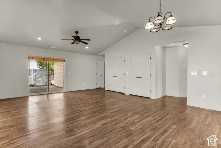Vaulted ceiling featuring a ceiling fan, recessed lighting, and a chandelier