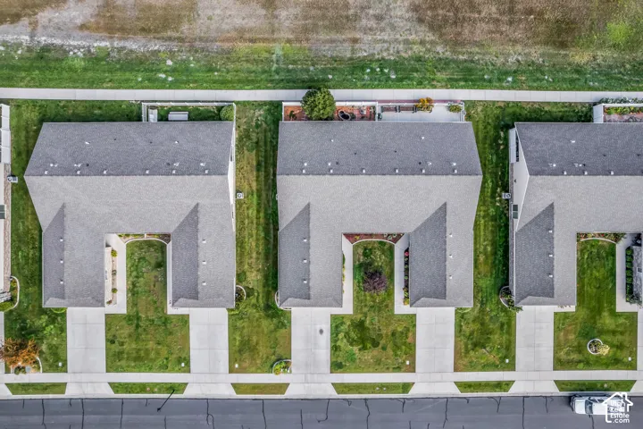 Multiple properties featuring gray shingle roofs, concrete driveways, and landscaped green spaces