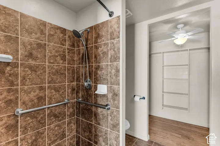 Tiled shower with grab bars and a handheld showerhead