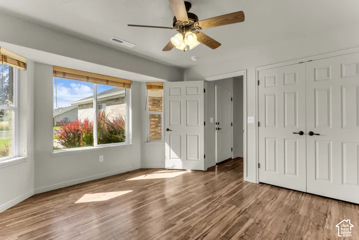 Wood-finish flooring throughout, bright white walls, and a multi-pane window with natural light