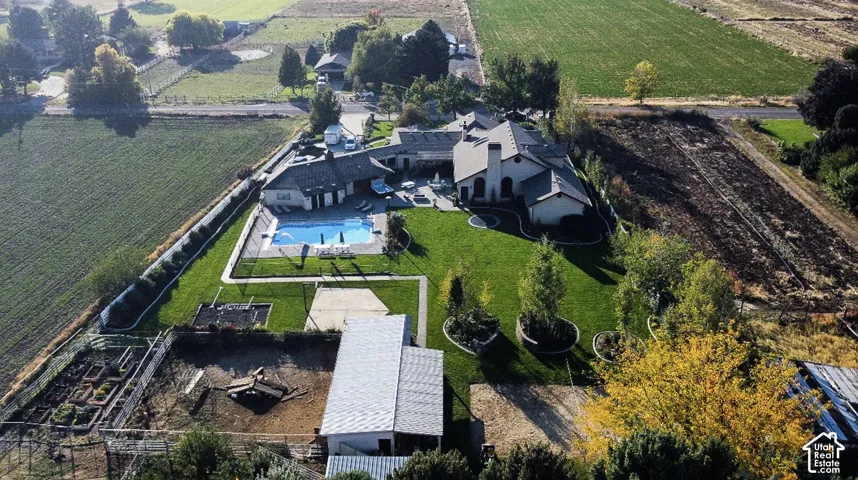 Expansive grounds featuring a swimming pool, manicured lawn, and dedicated garden beds