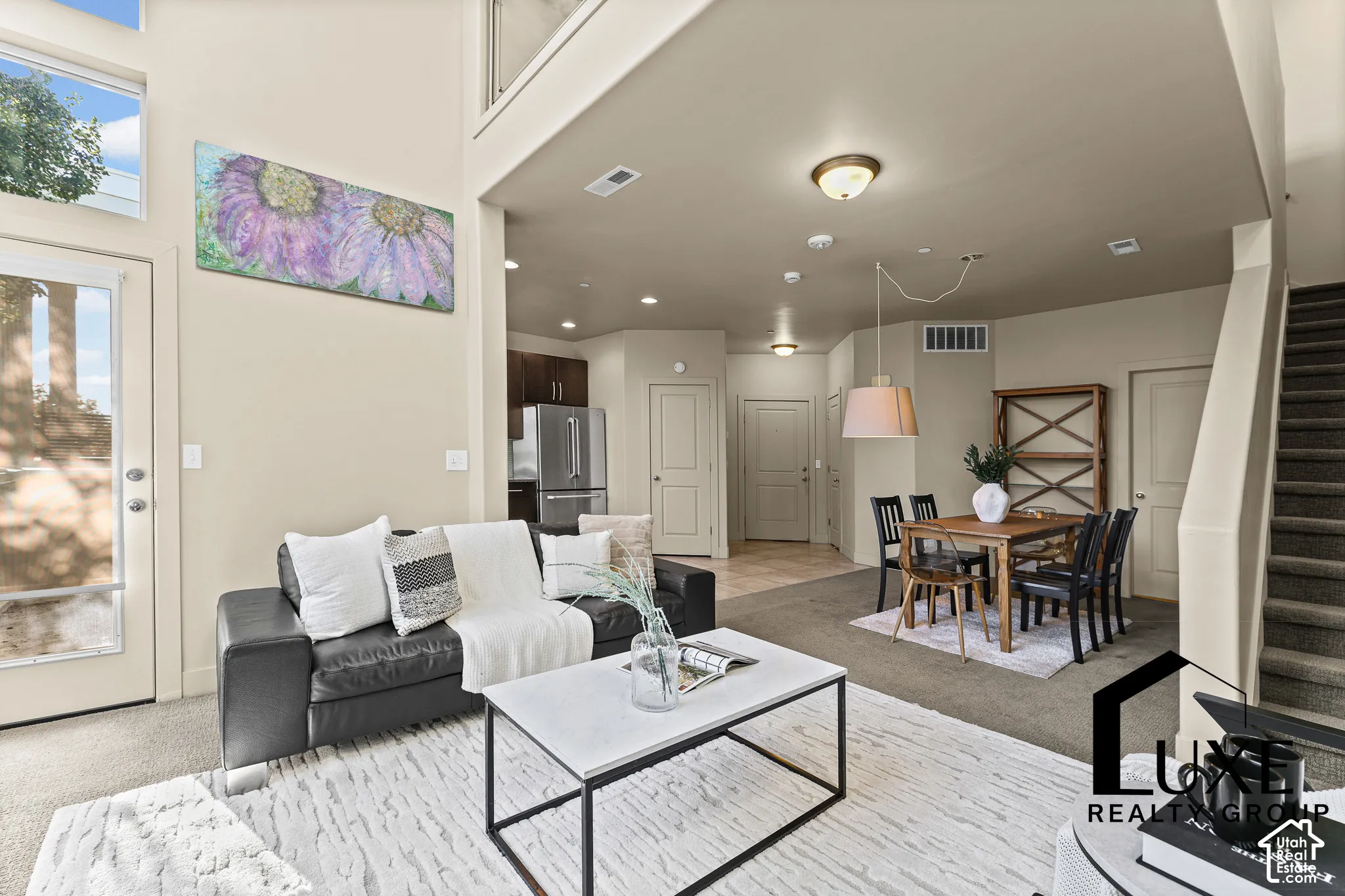 Two-story living area with high ceilings, large windows.