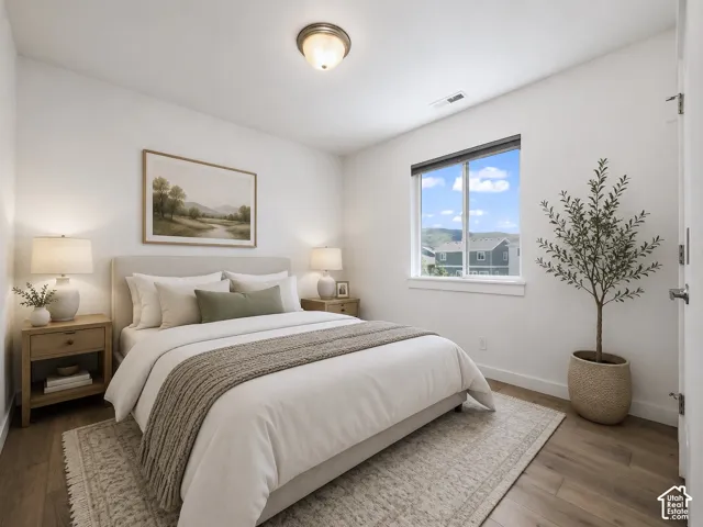 Spacious room featuring wood-finish flooring, a large window, and recessed lighting