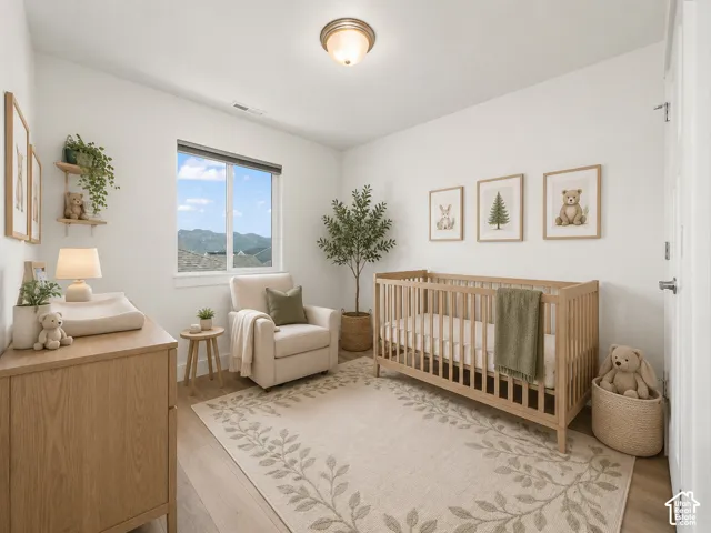 Recessed window offering expansive exterior scenery, light wood-finish flooring, and a flush-mount ceiling light fixture