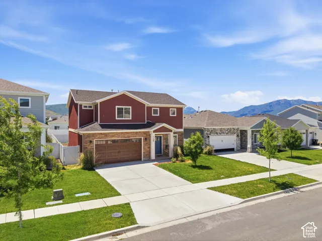 Two-story residence featuring a two-car garage, stone veneer and siding facade, and a concrete driveway