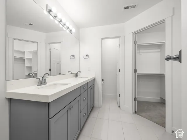 Dual vanity with integrated sinks, light-colored countertop, and gray cabinetry
