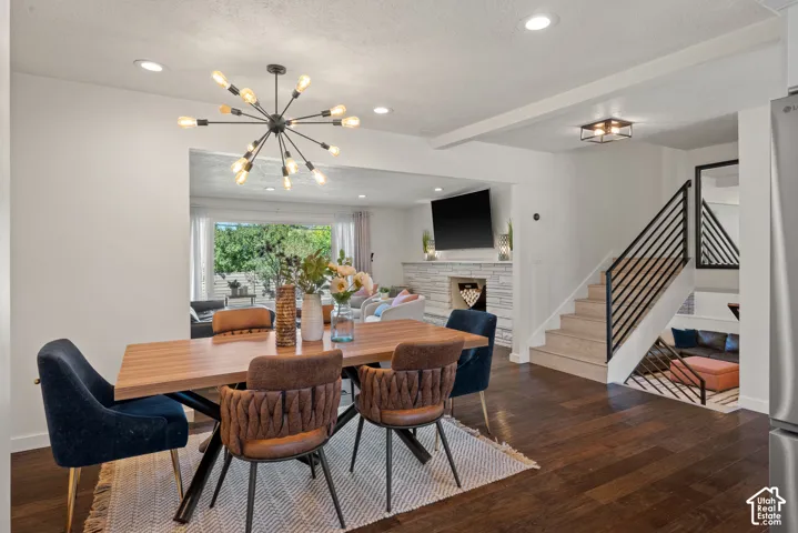 Wood-finish flooring, recessed lighting, modern sputnik chandelier, open-concept living space, and a contemporary staircase with metal railings