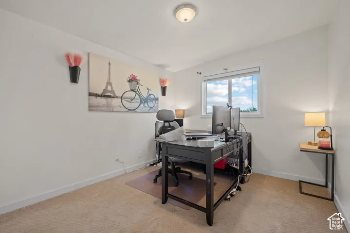 Dedicated home office featuring neutral carpeting, recessed ceiling lighting, and large windows providing natural illumination