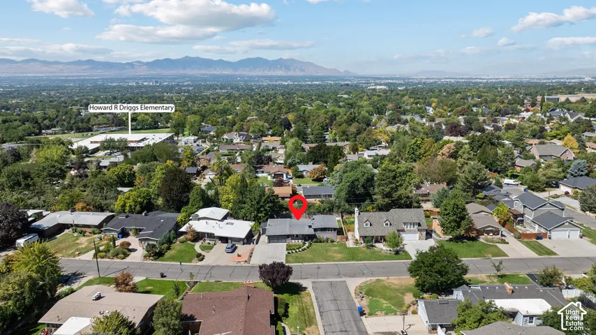 Aerial view showcasing this residential property situated on a tree-lined street within an established neighborhood