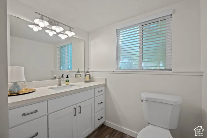 Bright and functional bathroom featuring a double-sink vanity with ample storage, white cabinetry, and wood-finish countertops