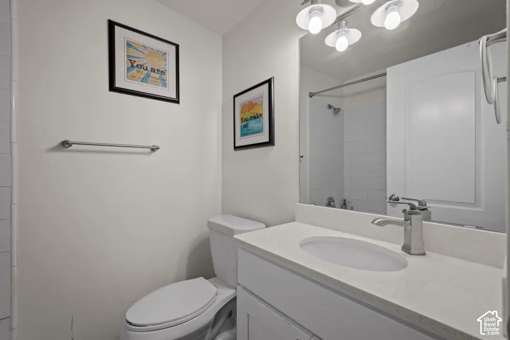 Modern bathroom featuring a white quartz countertop with an undermount sink, chrome wall-mounted faucet, and large framed mirror