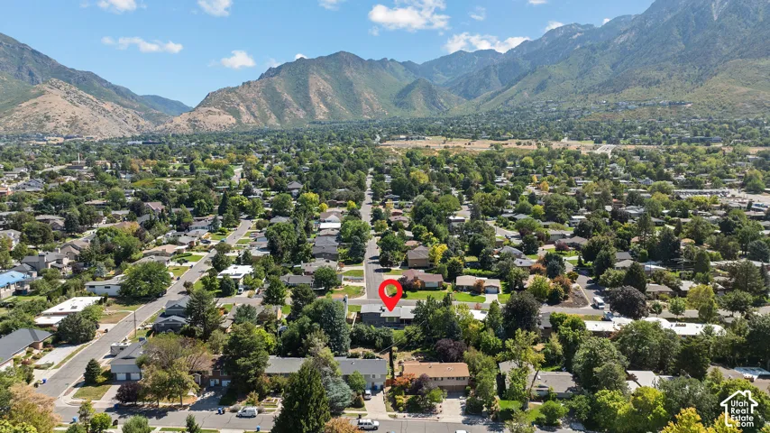 Aerial perspective showcasing a tree-lined residential neighborhood nestled against dramatic mountain foothills