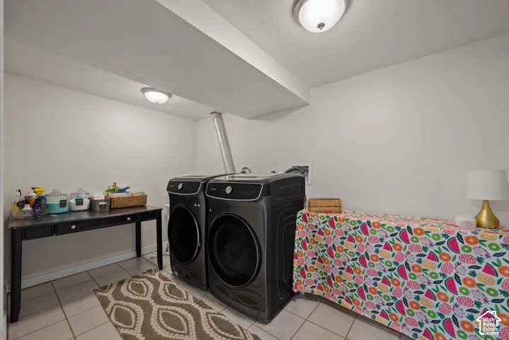 White walls and ceiling, flush-mount ceiling lights, light-toned tile flooring, and exposed ductwork