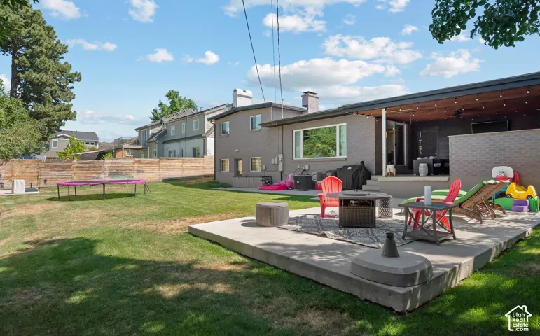 Expansive backyard retreat featuring a composite deck with integrated seating, mature landscaping, and manicured lawn